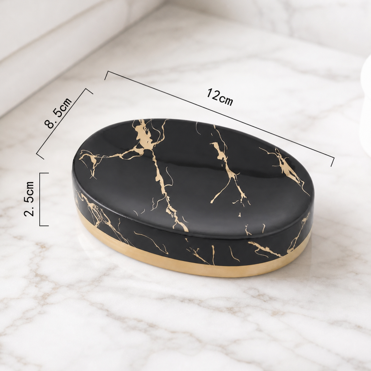 Oval black marble soap dish with gold veining and a gold base, shown on a white marble surface with dimension lines indicating 12cm length, 8.5cm width, and 2.