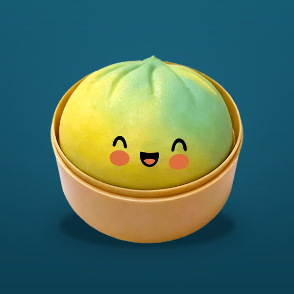 Yellow-green squishy bun with a smiling face in a tan steamer basket