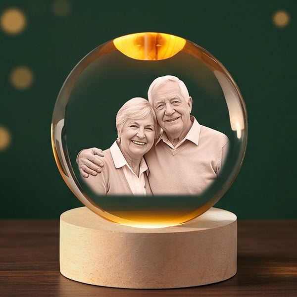 Example engraving: smiling grandparents inside a glowing crystal ball on its wooden base.