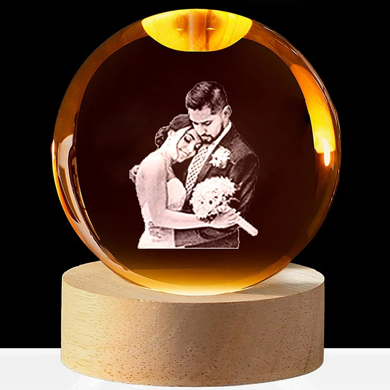 Real sample: a wedding couple engraved inside the crystal ball, glowing warm on its round wooden base