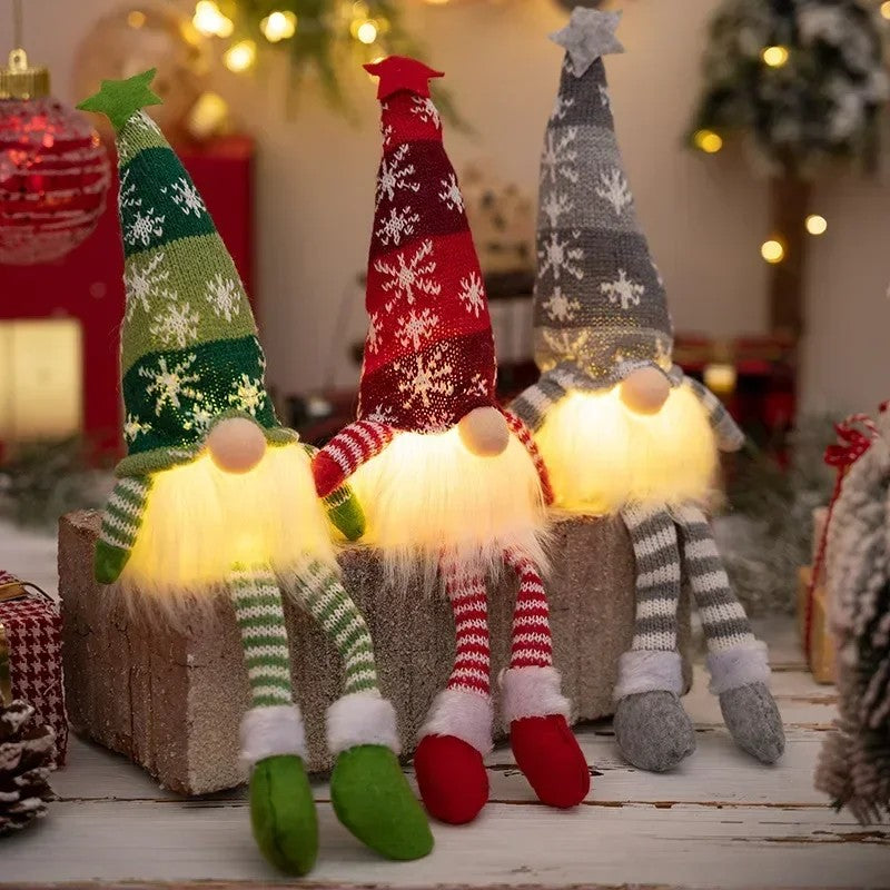 Three glowing faceless knit Christmas gnomes with long legs in green, red and grey