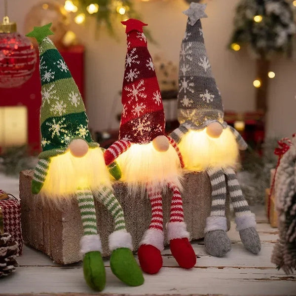 Three glowing faceless knit Christmas gnomes with long legs in green, red and grey