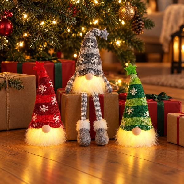 Red and green Classic gnomes and a grey Long Legs gnome glowing among gifts under a Christmas tree