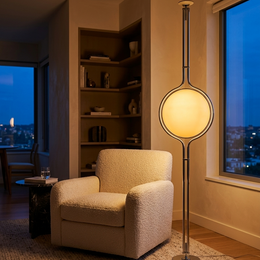 Alba floor lamp beside an armchair in a living room corner at dusk