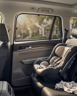 Scudo shade on a rear car window beside a baby seat