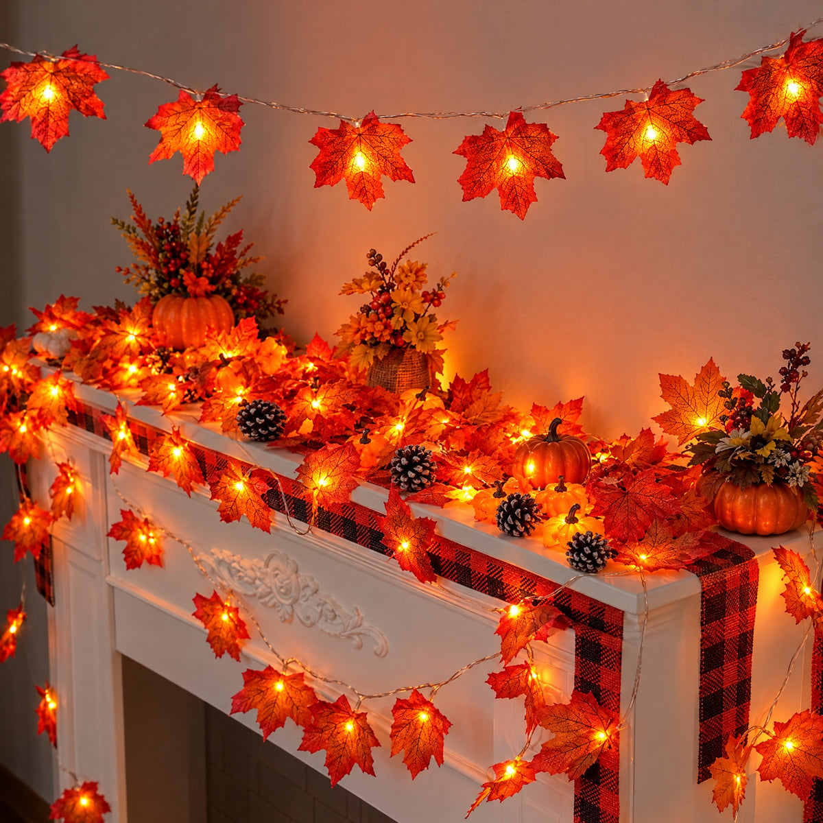 LED maple leaf garlands glowing across a white fireplace mantel and along the wall above it. Several garlands shown; pumpkins, pinecones, plaid runner and other decor not included