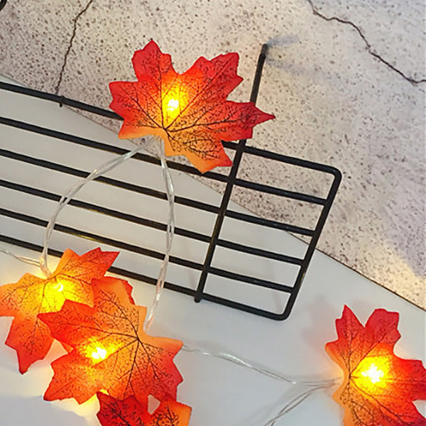 Glowing maple leaves hanging on a black wire rack